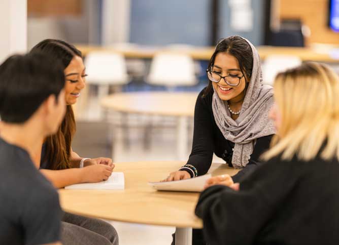 Students studying at a table in Des Plaines campus.